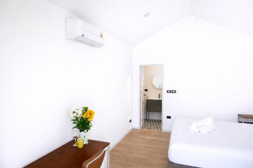 a bedroom with two beds and a table with flowers at Travellers Palm in Ko Phangan