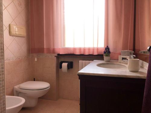 a bathroom with a toilet and a sink and a window at La Presentosa in Ortona