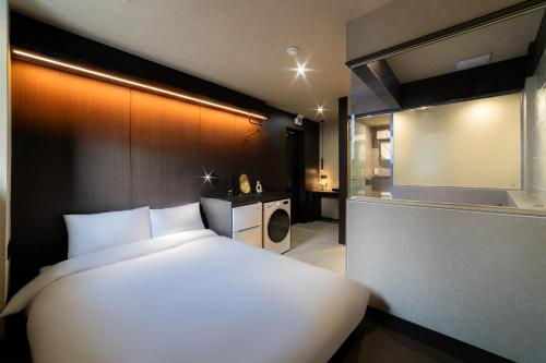 a bedroom with a large white bed and a bathroom at 해치 호스텔 in Seoul