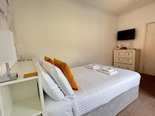 a bedroom with a bed with two towels on it at Gumfreston Guest House in Tenby