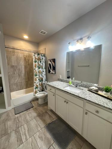 a bathroom with a sink and a toilet and a shower at Spacious Family Townhouse in Edmond