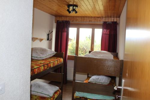 a room with two bunk beds and a window at Anzère appartement de vacances calme et sympa in Anzère