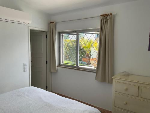 a bedroom with a bed and a window at Casa Nicho in Vale do Lobo