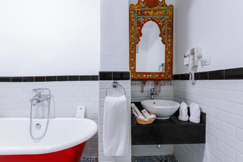 a bathroom with a tub and a sink and a mirror at Basma Hotel Aswan in Aswan