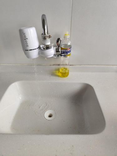 a sink with water coming out of a faucet at Jandira Hosting Acomodação in Jandira