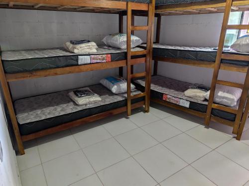 a room with three bunk beds in a room at Jandira Hosting Acomodação in Jandira