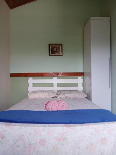 a bed with pink pillows on top of it at Chalé Romântico in Extrema