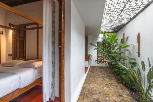 a bedroom with a bed and plants in a room at The Oneness Living- Seasonal Heritage stay with Tholpaavakoothu nights in Pazhayannūr