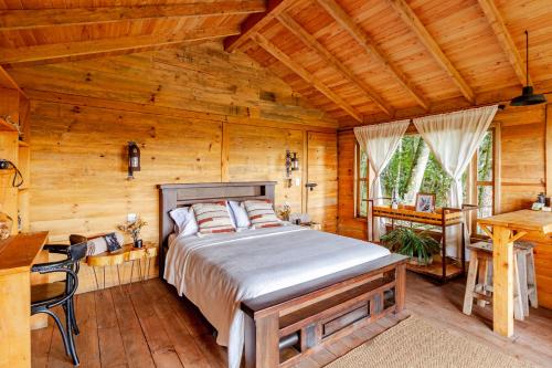 a bedroom with a bed in a wooden room at Refugio para desconectar, cabaña del ermitaño en medio del bosque in La Ceja