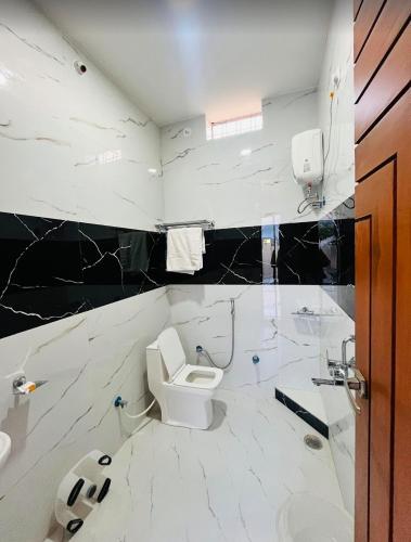 a white bathroom with a toilet and a sink at Vasudeva Villas in Udaipur