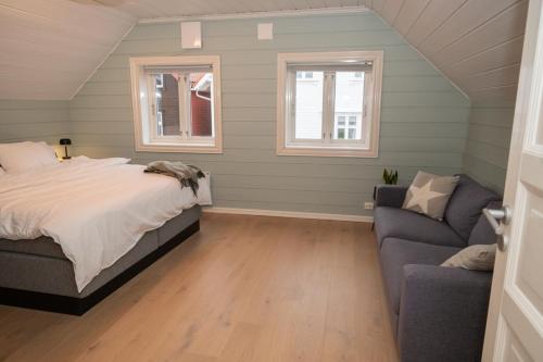 a bedroom with a bed and a couch at Classic Stavanger Townhouse, Garden, Spacious in Stavanger