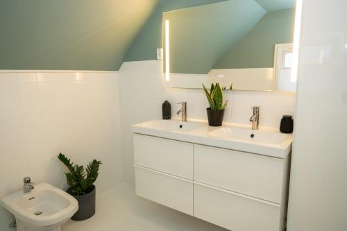 a bathroom with two sinks and a toilet at Classic Stavanger Townhouse, Garden, Spacious in Stavanger
