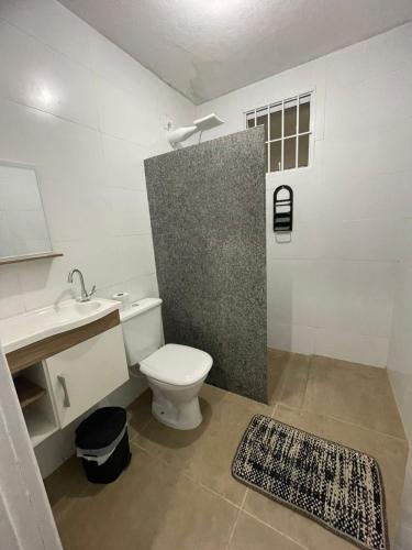 a bathroom with a toilet and a sink at kit net central 2 in Serra Negra