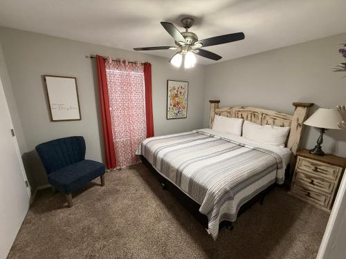a bedroom with a bed and a fan and a chair at Branson Ridge Retreat in Branson