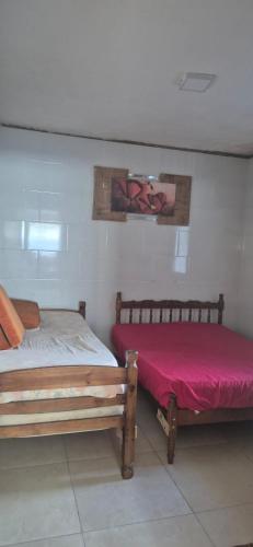 two beds sitting next to each other in a room at Cantinho de conforto in Mongaguá