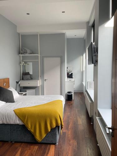 a bedroom with a bed with a yellow blanket on it at School house Portaferry in Portaferry