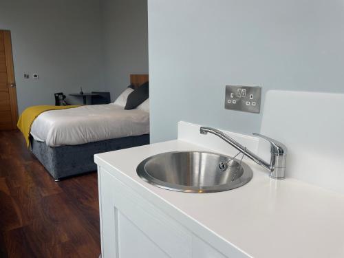 a bathroom with a sink and a bed in a room at School house Portaferry in Portaferry