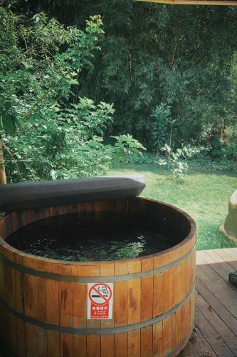 a large wooden barrel with a water fountain in it at Ônibus Oriental com Ofurô - Domingos Martins ES in Domingos Martins