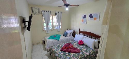 a small bedroom with a bed and a window at Família Castro Ostras in Rio das Ostras