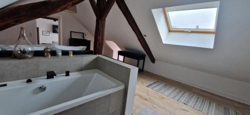 a large white bath tub in a room with a window at Maison Monéteau 6 personnes in Monéteau