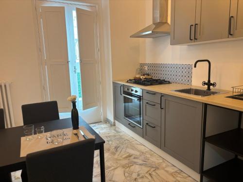 a kitchen with a table and a sink and a stove at Acqua Holiday House in Taranto
