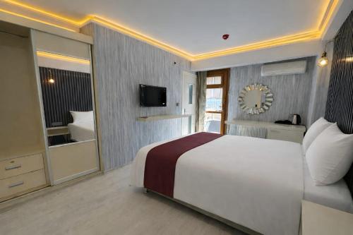 a bedroom with a large bed and a television at zebra otel buca in Buca
