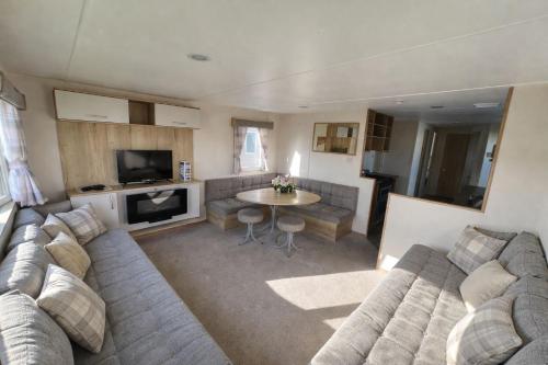 a living room with a couch and a table at Reeva's Resort at Littlesea Holiday Park, Weymouth in Wyke Regis