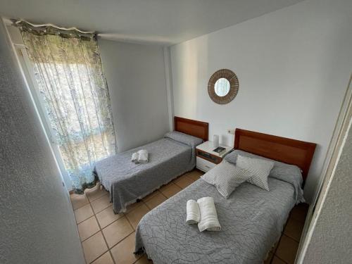 a bedroom with two beds and a mirror at Vinaros Cala Montero 2 in Vinarós