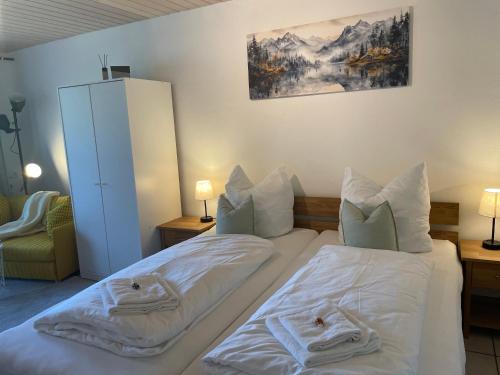 a bedroom with two beds with white sheets at Ferienwohnung am Storchennest in Ichenhausen