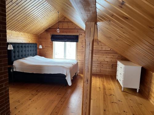 a bedroom with a bed in a wooden cabin at Askebo Norregård in Askebo
