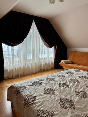 a bedroom with a bed and a large window at Saules home Jomas - early check in, late check out in Jūrmala