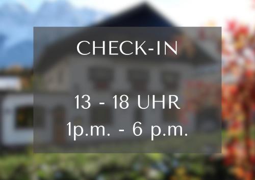a sign in front of a house that says check in at Zum Franziskaner in Grainau