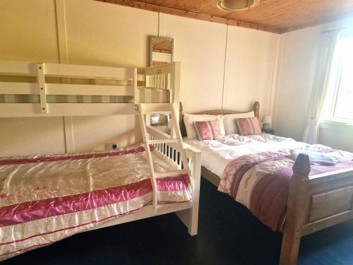 a bedroom with two bunk beds and a window at The Cosy Cabin in Swinford
