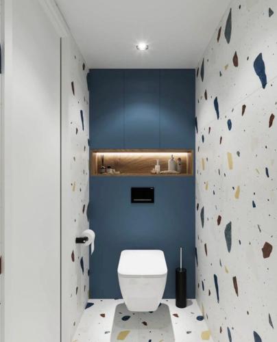 a bathroom with a white toilet and a rock wall at WBR Apartlak in Villány
