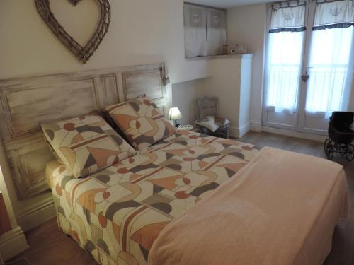 a bedroom with a bed and a mirror on the wall at Auprès du Lavoir in Remigny