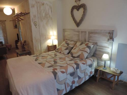 a bedroom with a bed with a heart on the wall at Auprès du Lavoir in Remigny