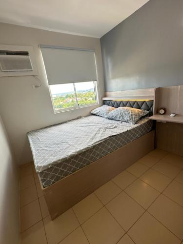 a small bed in a room with a window at Executive Family Condo Unit in Iloilo City