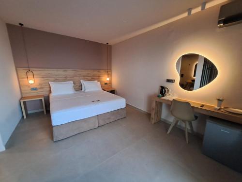 a bedroom with a bed and a desk and a mirror at Castella Luxe in Loutro