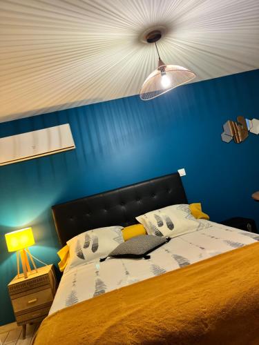 una camera da letto con un grande letto e una parete blu di Naphéo a Tonnay-Charente