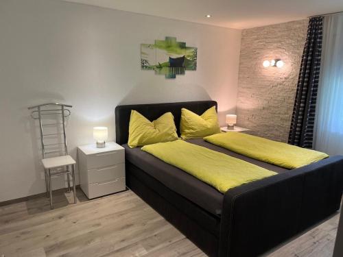a bedroom with a black bed with yellow sheets and a yellow blanket at Papillon in Saas-Grund