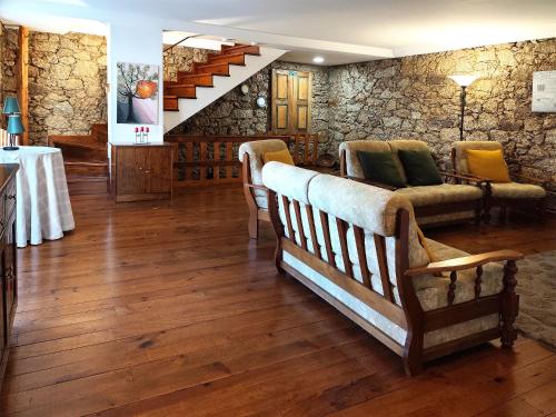 a living room with a couch and a stone wall at casa na aldeia - entre Fundão e Covilhã in Pêro Viseu