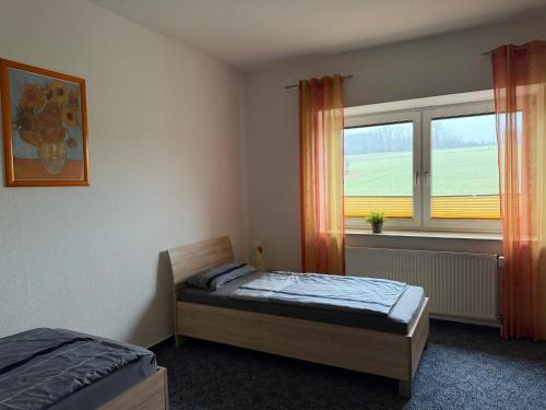 a small bedroom with a bed and a window at Wiehengebirgs Fernblick App 2 in Bad Essen