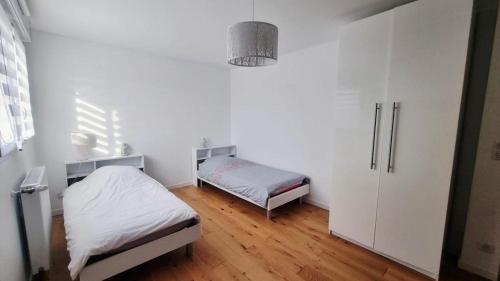 a white room with two beds and a cabinet at Superbe Maison avec jardin in Bezannes-les-Reims