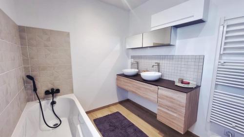 a bathroom with two sinks and a bath tub at Superbe Maison avec jardin in Bezannes-les-Reims