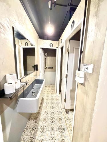 a bathroom with a tub and a sink and a mirror at Arun Old Town in Bangkok