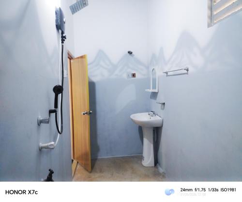 a bathroom with a shower and a toilet and a sink at Almond Breeze Cottage in Udawalawe