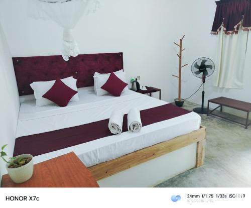 a bedroom with a large bed with towels on it at Almond Breeze Cottage in Udawalawe