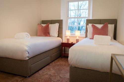two beds sitting next to each other in a room at River View Cottages in Annan