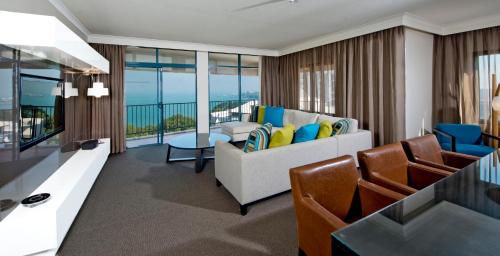 a living room with a couch and a table at Mantra on The Esplanade in Darwin