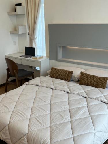 a bedroom with a bed and a desk with a laptop at Leegarden Apartment-3BR in Sibu